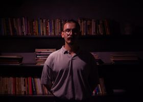 Author reading in a library by lamplight